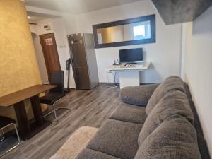 a living room with a couch and a desk at Apartament Gara de Nord in Bucharest