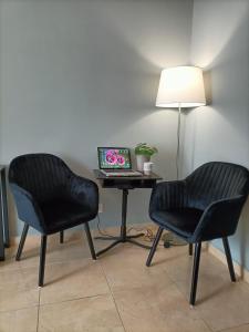 two chairs and a laptop on a table with a lamp at Testaccio Bodoni apartment in Rome