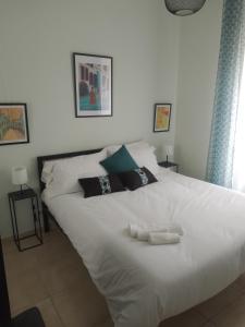 a white bed with two towels on top of it at Testaccio Bodoni apartment in Rome