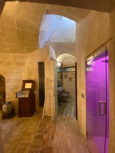 a bathroom with a purple door and a sink at Maison d'Ax in Matera