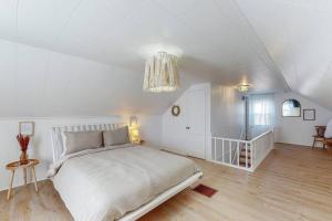 a white bedroom with a bed and a chandelier at End Zone Escape-Light and Bright HOF Village Home in Canton