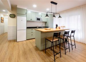 贝梅奥Astillerogane的厨房配有带椅子和台面的岛屿