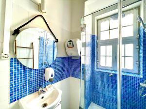 y baño de azulejos azules con lavabo y ducha. en Algarve HOSTEL, en Faro