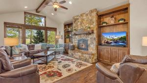 sala de estar con chimenea de piedra y TV en Caldera Cabin 6, en Sunriver