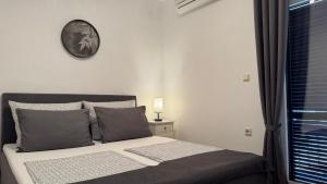 a bedroom with a bed with a clock on the wall at Apartments Ein Haus in der Sonne in Malinska