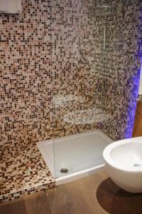 een badkamer met een douche, een toilet en een wastafel bij Barbacan Boutique Hotel in Trieste