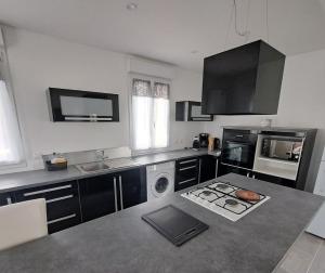 a kitchen with a sink and a dishwasher at Au Clair matin sur l'Yères in Sept-Meules