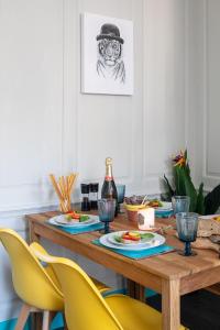 Dream Stays Bath - Kingsmead Street في باث: طاولة طعام مع كراسي صفراء وطاولة مع طعام