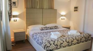 a bedroom with a bed with two pillows on it at Barbacan Boutique Hotel in Trieste