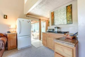 a kitchen with a white refrigerator and wooden cabinets at Auburn Cottage with Patios and Garden - 3 Mi to Town! in Auburn