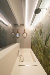 a bathroom with a sink and a painting on the wall at ISONZO SUITES in Siracusa