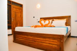 a bedroom with a bed with an orange towel on it at Ocean Grace in Arugam Bay