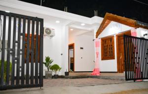 a white house with a door and a gate at Ocean Grace in Arugam Bay