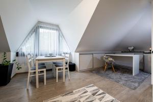 a dining room with a table and a desk at Chillgarden Apartments in Trenčín