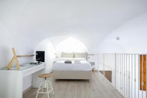 Un dormitorio blanco con una cama y un escritorio. en La tua casetta, en Ascoli Piceno