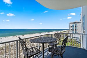 balcón con mesa y sillas y la playa en Spanish Key Unit 506, en Pensacola
