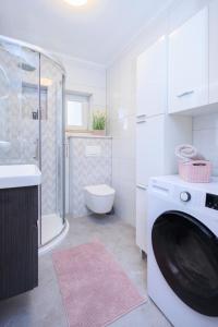 a bathroom with a washing machine and a toilet at Apartment Maya in Podstrana +98 photos
