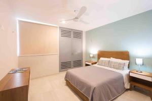 Un dormitorio con una cama, un escritorio y un ventilador de techo. en Meridia 3, en Mérida