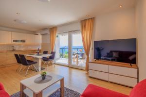 a living room with a kitchen and a living room with a table at Apartment Maya in Podstrana