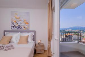 a bedroom with a bed and a window with a view at Apartment Maya in Podstrana
