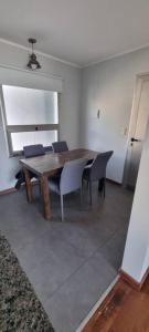 a dining room with a wooden table and chairs at Ushuaia 1 in Rosario +7 photos