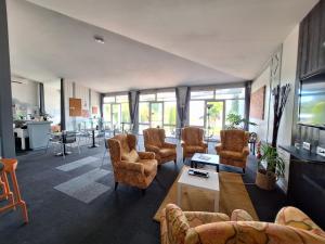 a living room with a bunch of chairs and a tv at Escale Kennedy in Mérignac
