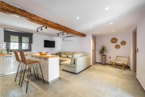 Una cocina y una sala de estar con un sofá y una mesa. en Buonora D'oro Villa, en Tsoukaladhes
