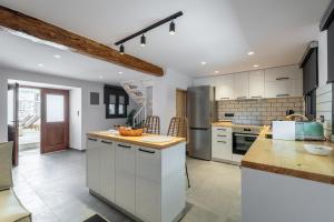 Una cocina con gabinetes blancos y encimera. en Buonora D'oro Villa, en Tsoukaladhes