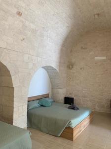 Un dormitorio con una cama en una pared de piedra. en Villa Cosmo, en Alberobello
