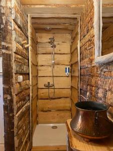 y baño con ducha en una pared de madera. en La Cabane trappeur, en Gravières