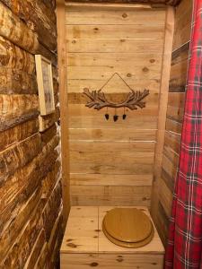 una sauna de madera con un cartel en la pared en La Cabane trappeur, en Gravières 6 fotos más