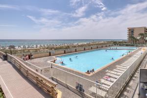 - une piscine avec la plage en arrière-plan dans l'établissement Waters Edge Condominiums, à Fort Walton Beach