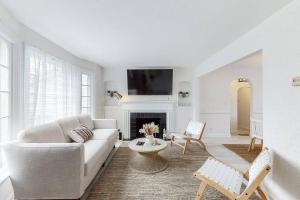 a white living room with a couch and a fireplace at The Perfect Pass-HOF Village Escape in Canton