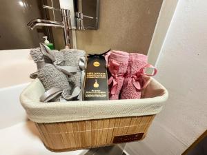 - un panier de serviettes sur un lavabo dans la salle de bains dans l'établissement Venus Central Lux Studio, à Craiova