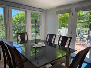uma sala de jantar com uma mesa de vidro e cadeiras em Pleasant Bay Village Resort em Chatham