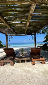 duas cadeiras sentadas sob um gazebo na praia em Sal Si Puedes em Tintipan Island