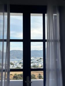 a window with a view of a city at Kapetan Giannis in Adamantas