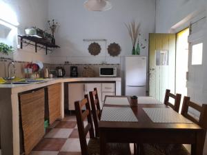 a kitchen with a table and a kitchen with a refrigerator at Casa Calma in Colonia del Sacramento
