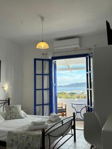 a bedroom with a bed and a balcony with a view at Kapetan Giannis in Adamantas