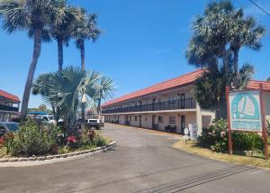 een hotel met palmbomen voor een gebouw bij A1A Brownwaves in St. Augustine