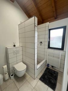 a white bathroom with a toilet and a window at Stilvolle Wohnung mit Terasse und Garten in Höhr-Grenzhausen