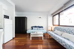 ein Wohnzimmer mit einem Sofa und einem Tisch in der Unterkunft Loft moderno y cómodo a un minuto de Las Canteras in Las Palmas de Gran Canaria
