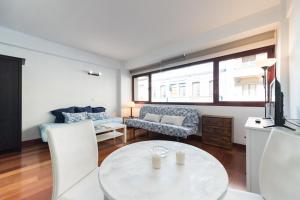 ein Wohnzimmer mit einem Tisch und einem Sofa in der Unterkunft Loft moderno y cómodo a un minuto de Las Canteras in Las Palmas de Gran Canaria