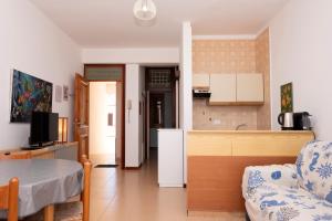 a kitchen and a living room with a table at Appartamento Coryna sul Mare in San Vito lo Capo