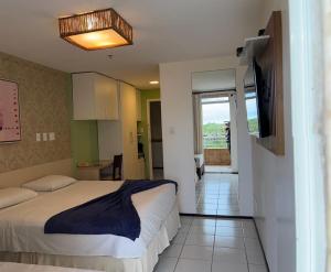 1 dormitorio con 1 cama y TV en la pared en Gran Lençóis Flat Barreirinhas, en Barreirinhas