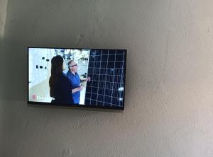 a flat screen tv hanging on a wall at Pousada Santos lll, kitnet confortável com ar condicionado in Londrina