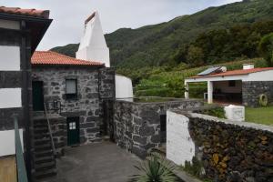 eine Außenansicht einer Kirche mit einem Kirchturm in der Unterkunft Casa da Ermida in Velas