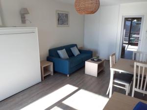 a living room with a blue couch and a table at T1 avec piscine et terrasse au coeur de La Rochelle in La Rochelle +13 photos