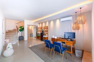 Coralia Hotel Cozumel في كوزوميل: غرفة معيشة مع مكتب وكراسي زرقاء
