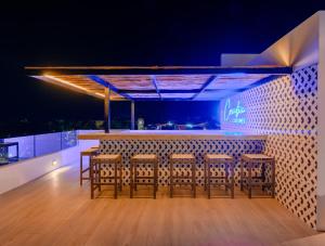 Coralia Hotel Cozumel في كوزوميل: بار مع كراسي وطاولة مع أضواء